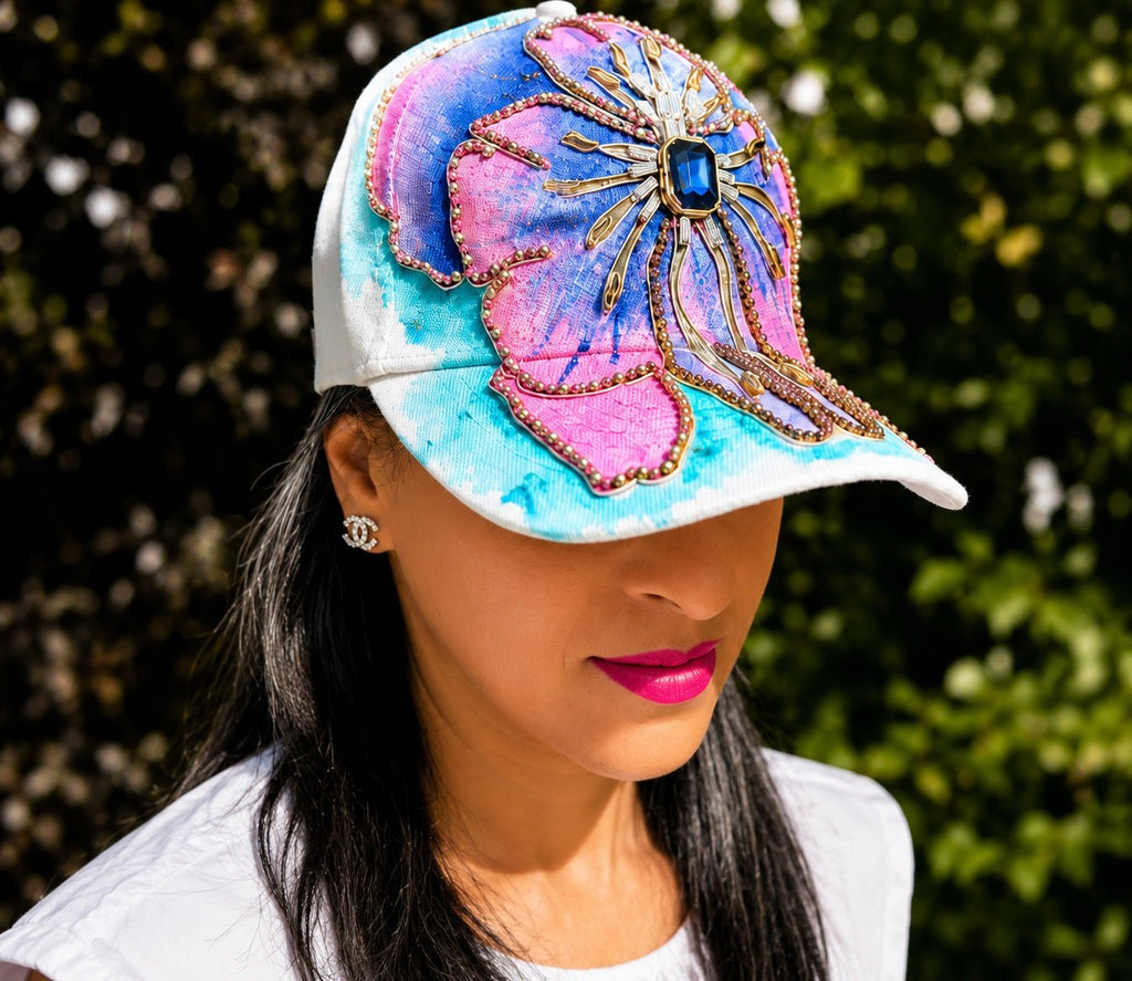 Person wearing a colorful cap with floral design against a blurred green background